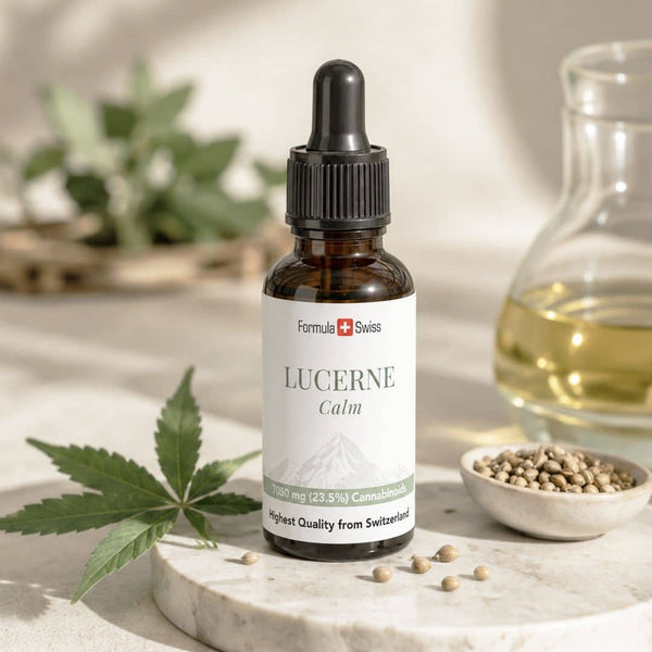 Formula Swiss Lucerne Calm cannabinoidolja i en flaska, presenterad med hampablad, frön och gyllene olja i en ljus, naturlig miljö.